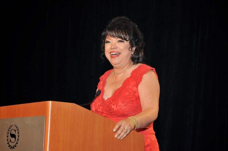 Linda Mazon Gutierrez speaking at podium